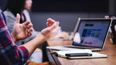 Hands explaining in front of a laptop