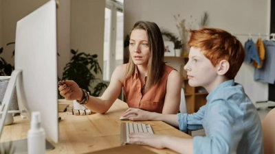 Vrouw legt kind iets uit op computer