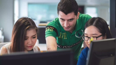 Docent legt uit bij studenten achter computer