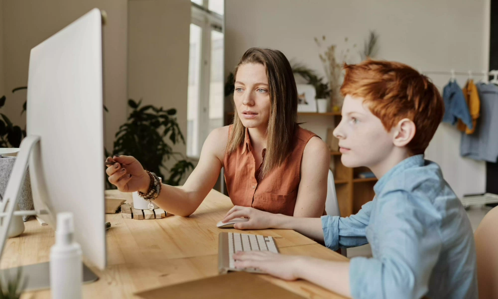 Vrouw legt kind iets uit op computer